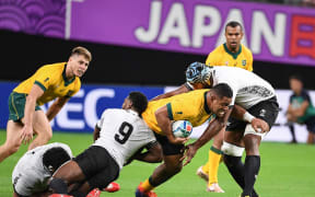 Australian prop Scott Sio tries to bust through the tackle in the World Cup match against Fiji.
