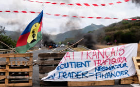 Opponents of the proposed sale of the Vale NC plant display independent Kanak flags on a filter dam on the outskirts of the agglomeration of Noumea.