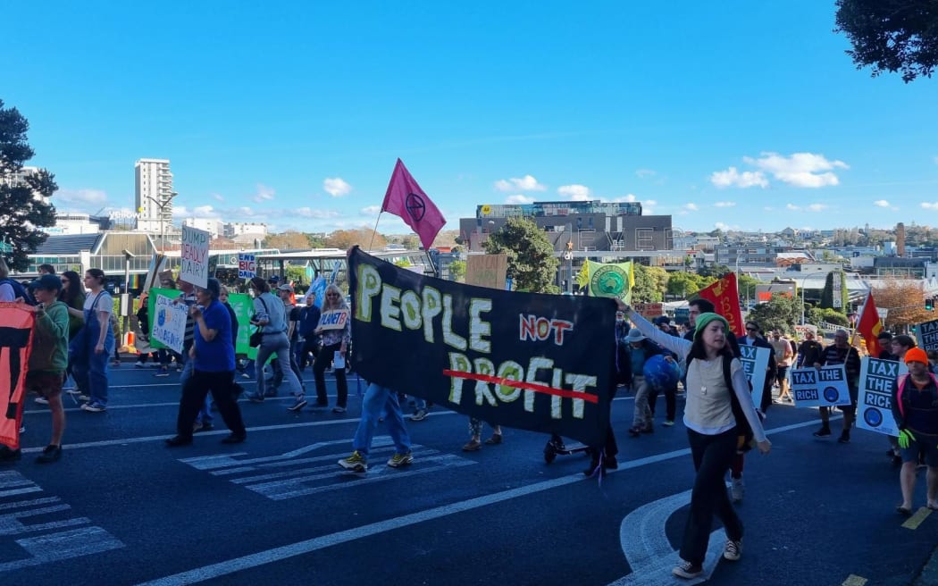 抗议者在奥克兰气候抗议活动中举着“people not profit”的横幅。