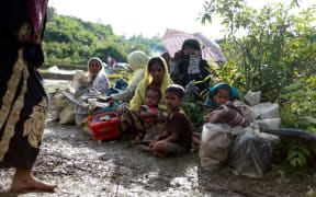 A Rohingya family sit beside a road in Nykkhongchhari, Bangladesh after fleeing violence in Myanmar.