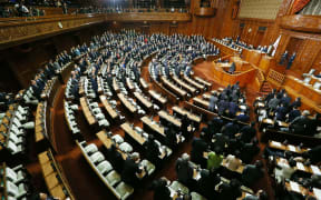 Ruling coalition lawmakers stand to approve the passage of the Trans-Pacific Partnership free trade deal in the lower house of the parliament in Tokyo.
