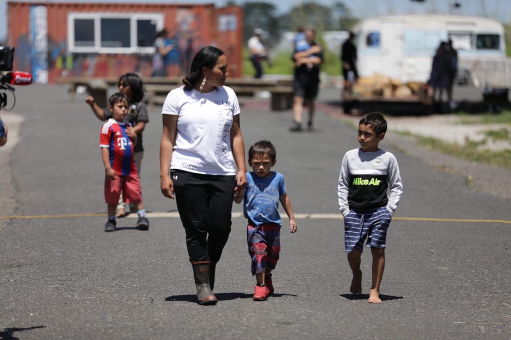 SOUL co-spokesperson Pania Newton holds the hand of a child while walking with others.