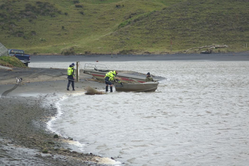 Locals and Landsar personnel at the Marokopa River estuary during the search for Thomas Phillips and his children.