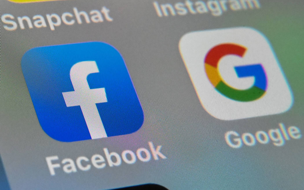Foto yang diambil pada 1 Oktober 2019 malam hari menunjukkan logo aplikasi seluler Facebook dan Google ditampilkan di tablet.  (Foto oleh Denis Charlet/AFP)