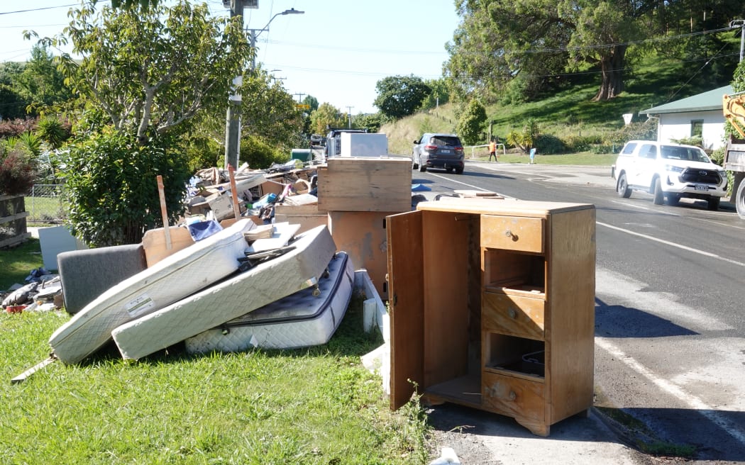 Puketapu's roads are piled with damaged household goods, but volunteers are removing the rubbish.