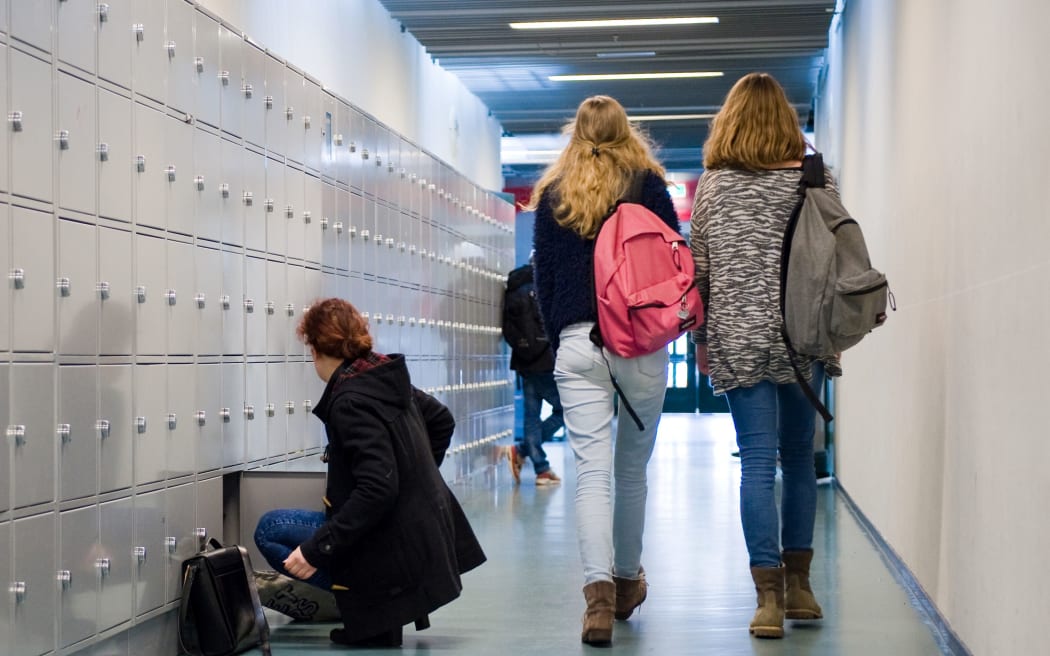 ENSCHEDE, THE NETHERLANDS - 02 FEB, 2015: Students are walking through a hallway with lockers on a high school