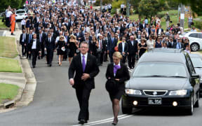A large procession of mourners follows the hearse carrying Phillip Hughes.
