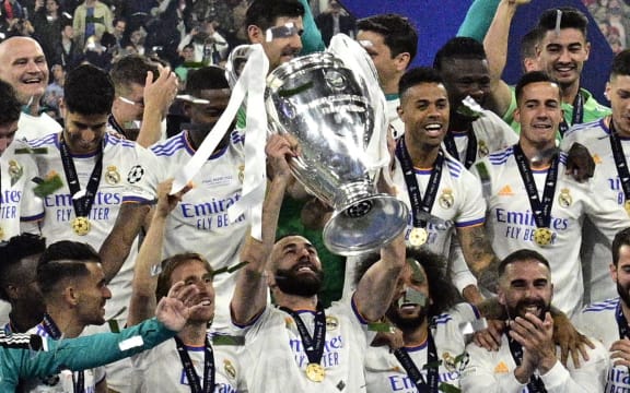 Real Madrid's French forward Karim Benzema (C) and his teammates celebrate with the trophy after the UEFA Champions League final football match between Liverpool and Real Madrid at the Stade de France in Saint-Denis, north of Paris, on May 28, 2022. - Real Madrid won the match 0-1.  (Photo by JAVIER SORIANO / AFP)