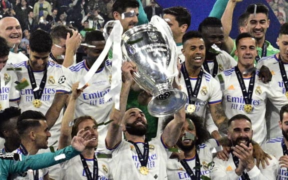 L'attaquant français du Real Madrid Karim Benzema (au centre) et ses coéquipiers célèbrent le trophée après le match final de l'UEFA Champions League entre Liverpool et le Real Madrid au Stade de France à Saint-Denis, au nord de Paris, le 28 mai 2022. - Real Madrid gagné le match 0-1.  (Photo de Javier Soriano/AFP)