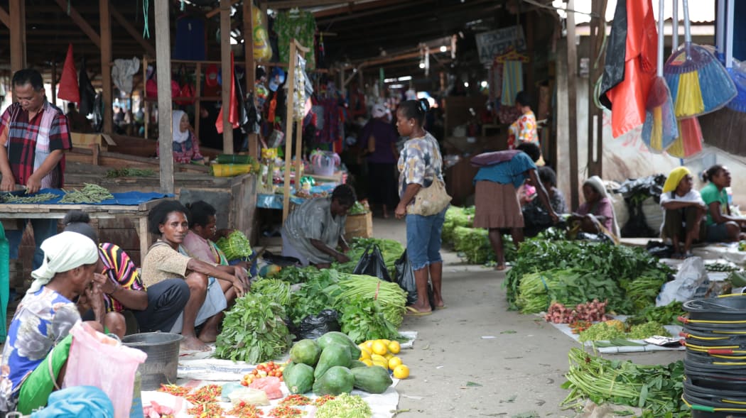 Papuan women sell produce in an old market in Sentani