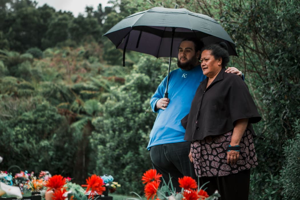 Albert and Lina Fairbrother stand under an umbrella at Taita Cemetery