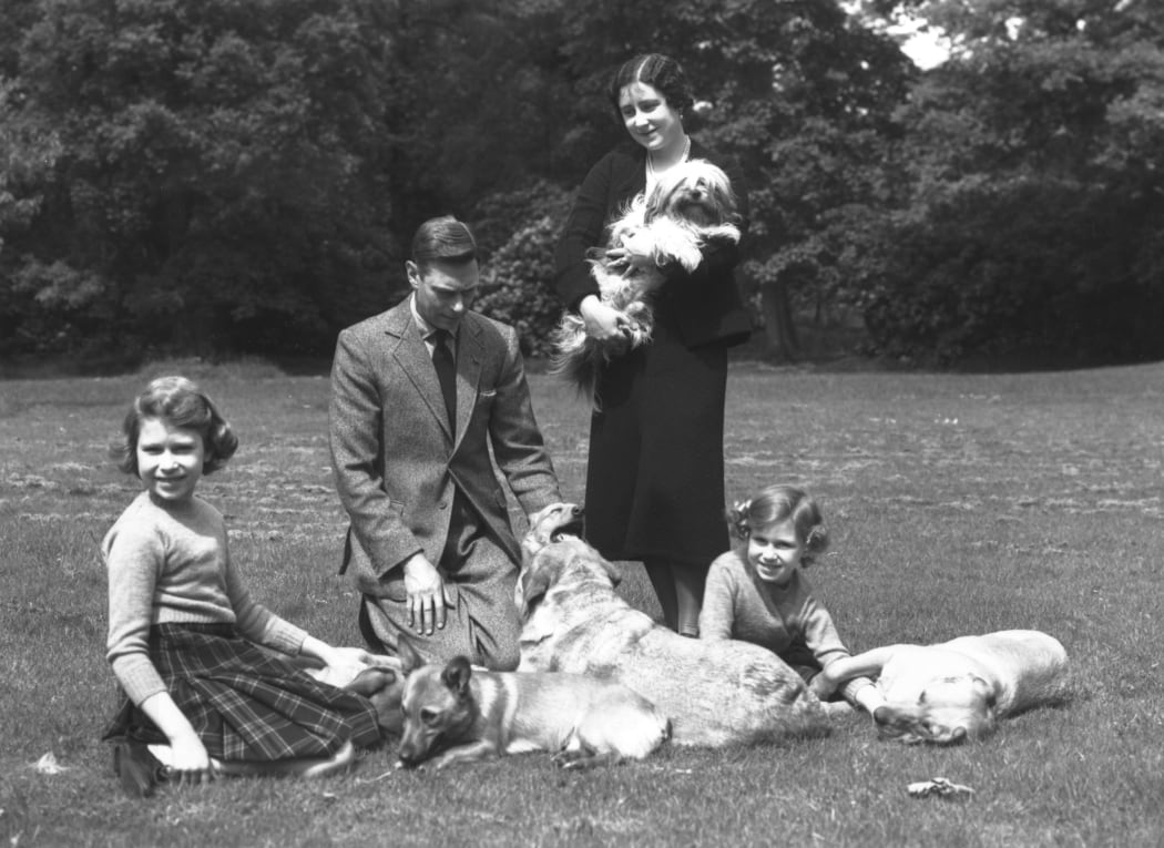 June 1936:  King George VI and Queen Elizabeth (Queen Elizabeth the Queen Mother) with the Royal Princesses Elizabeth (later Queen Elizabeth II) and Margaret (1930 - 2002) in the grounds of Windsor Castle with four dogs.  (Photo by Lisa Sheridan/Studio Lisa/Getty Images)