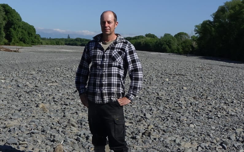 Ongaonga farmer Alistair Setter stands in the middle of the dry Waipawa River bed.
