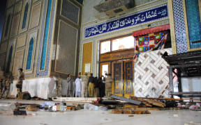 Debris is seen on the ground as Pakistani soldiers cordon off the shrine of 13th century Muslim Sufi Saint Lal Shahbaz Qalandar