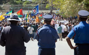 Papua New Guinea police officers watch on during a protest rally in 2013.