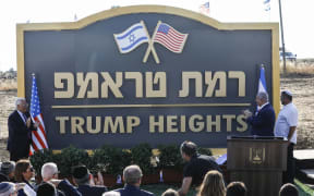 Israeli Prime Minister Benjamin Netanyahu (second from right) and US Ambassador to Israel David Friedman (left) applaud after unveiling the place-name sign for the new settlement of "Trump Heights" in the Golan Heights