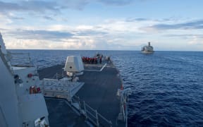 Arleigh Burke-class guided-missile destroyer USS Dewey prepares for a replenishment-at-sea with USNS Pecos, right, in the South China Sea on 19 May 2017.