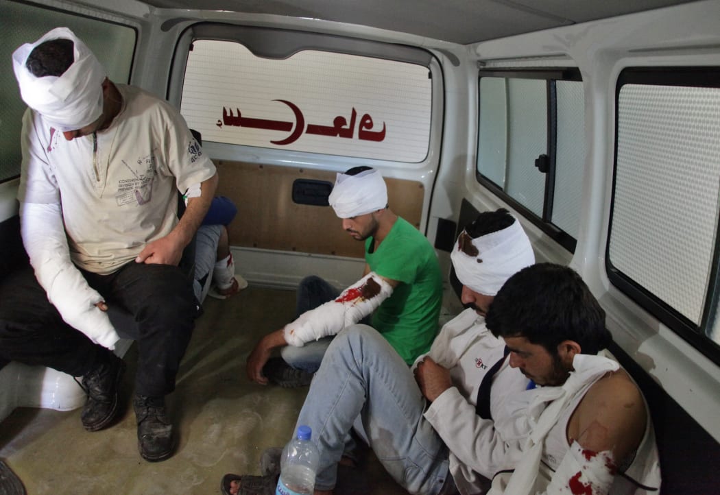 Wounded opposition fighters in an ambulance in Aleppo, as clashes erupted in an area designated as a humanitarian corridor for civilians to leave the embattled city, despite an announced pause in the Syrian army's Russian-backed offensive.