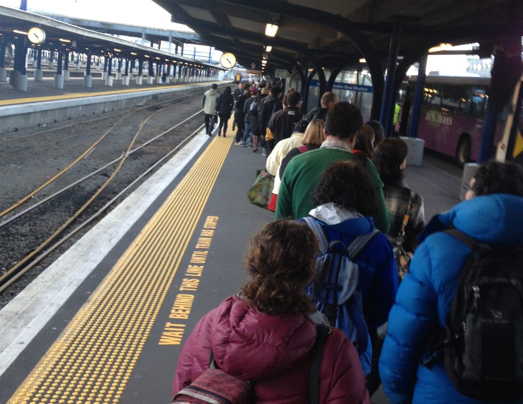 People queue for buses at the train station in Wellington.