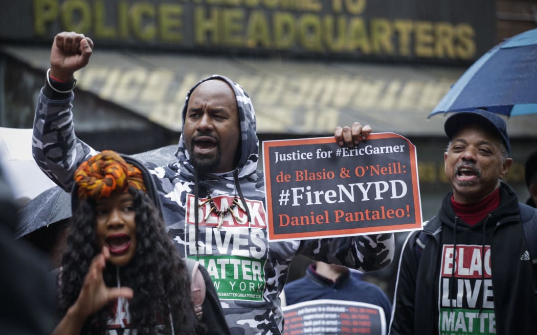 (FILES) In this file photo taken on May 13, 2019 People protest outside the police headquarters while a disciplinary hearing takes place for officer Daniel Pantaleo in New York City.
