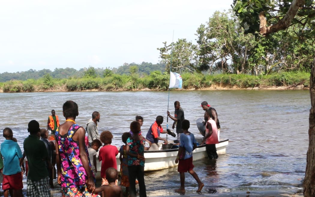Un groupe de villageois des îles Carteret est entré dans une baie pour recevoir un bateau de ravitaillement.