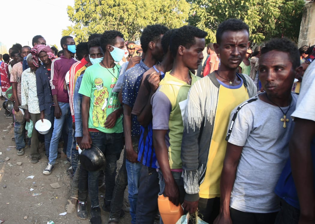 Ethiopian migrants who fled intense fighting in their homeland of Tigray, wait for their ration of food in the border reception centre of Hamdiyet, in the eastern Sudanese state of Kasala, on November 14, 2020.