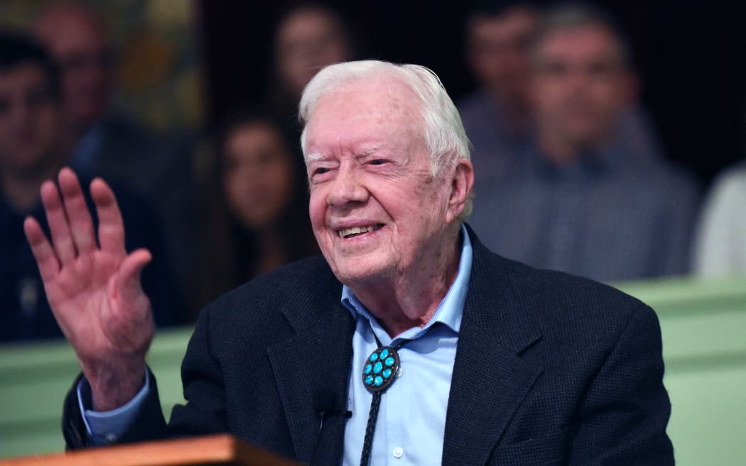 Former U.S. President Jimmy Carter waves to the congregation after teaching Sunday school at Maranatha Baptist Church in his hometown of Plains, Georgia on April 28, 2019. Carter, 94, has taught Sunday school at the church on a regular basis since leaving the White House in 1981, drawing hundreds of visitors who arrive hours before the 10:00 am lesson in order to get a seat and have a photograph taken with the former President and former First Lady Rosalynn Carter.  (Photo by Paul Hennessy/NurPhoto) (Photo by Paul Hennessy / NurPhoto / NurPhoto via AFP)
