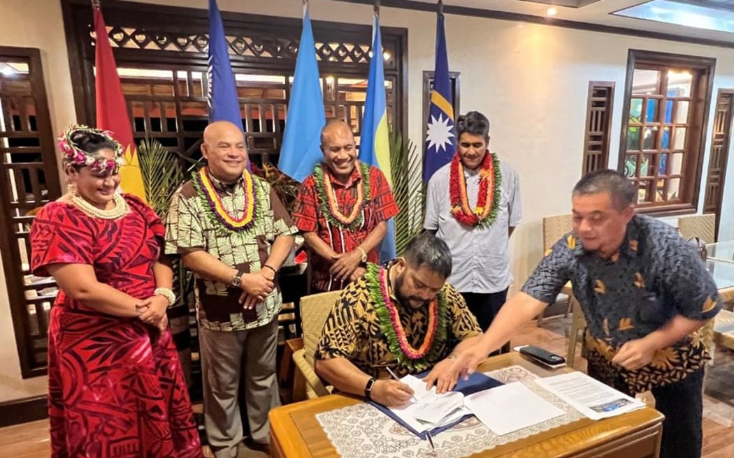 Russ Joseph Kun of Nauru signs a document surrounded by fellow presidents and ministers