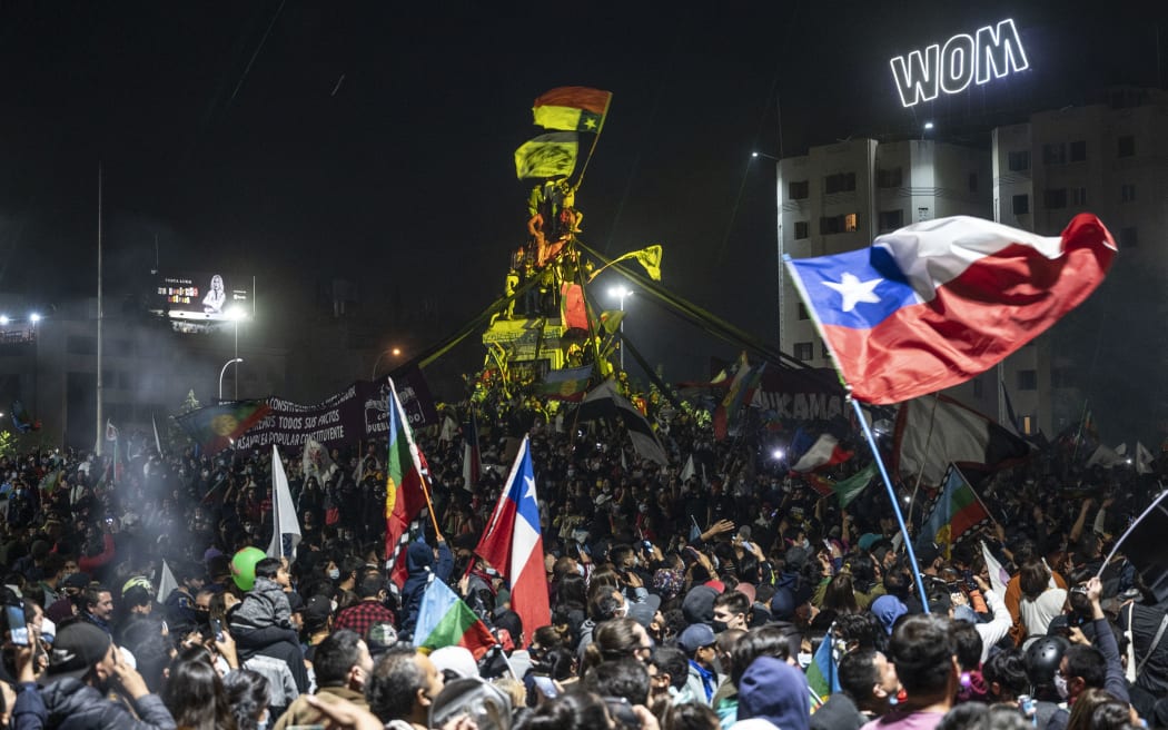 Demonstrators supporting the reform of the Chilean constitution celebrate the referendum official results at Plaza Italia square in Santiago on October 25, 2020.