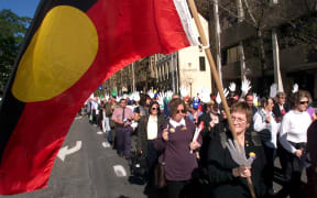 A woman waves an Aboriginal flag during a march to commemorate Sorry Day in Sydney 26 May 1999.