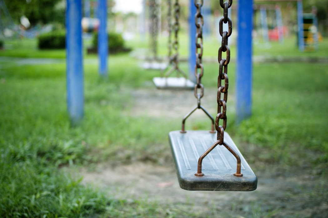 An empty swing at a children's playground