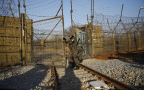 South Korean soldiers open the gate as the rails which leads to North Korea is seen, inside the demilitarized zone separating the two Koreas in Paju.