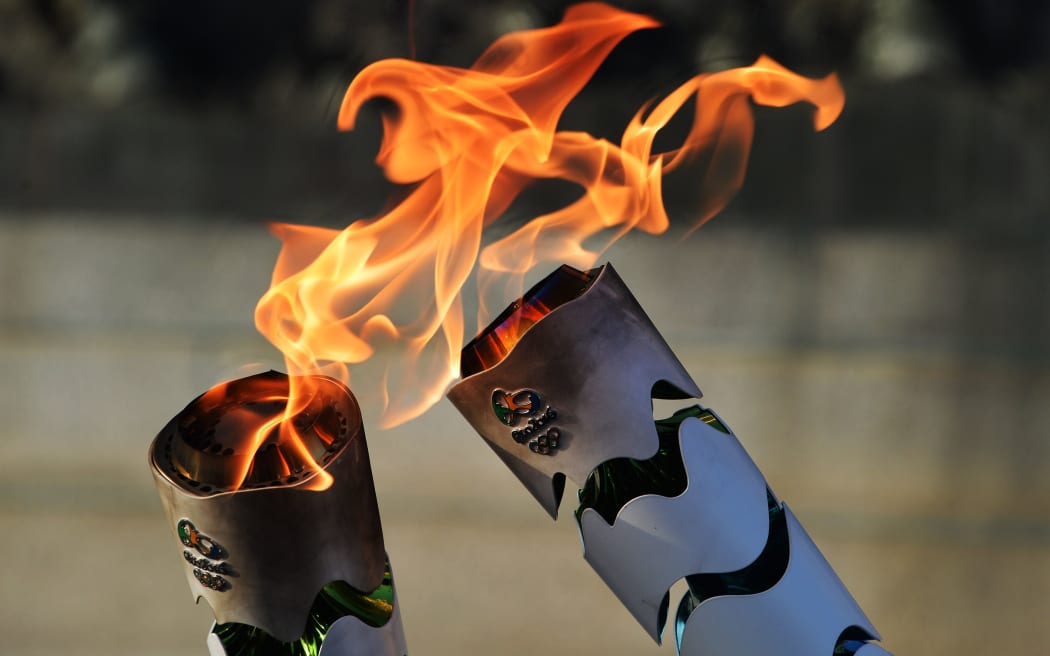 Brazilian residents pass the Olympic torch at Independence Park upon the flame's arrival in Sao Paulo, Brazil, on its way to the Rio Olympics.