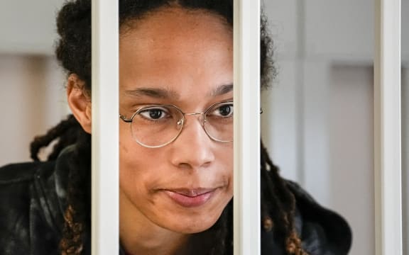 US WNBA basketball superstar Brittney Griner looks from inside a defendants' cage before a hearing at the Khimki Court, outside Moscow on July 26, 2022. - Griner, a two-time Olympic gold medallist and WNBA champion, was detained at Moscow airport in February on charges of carrying in her luggage vape cartridges with cannabis oil, which could carry a 10-year prison sentence. (Photo by Alexander Zemlianichenko / POOL / AFP)