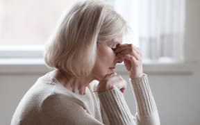 Fatigued older woman, headache, thinking, stress. (File photo)