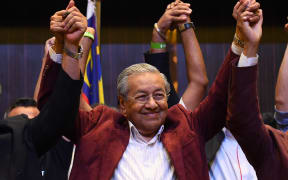 Former Malaysian prime minister and opposition candidate Mahathir Mohamad celebrates with other leaders of his coalition during a press conference in Kuala Lumpur.