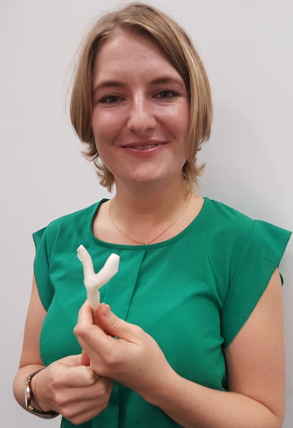 Susann Beier holds a larger-than-life size 3D-printed coronary artery.