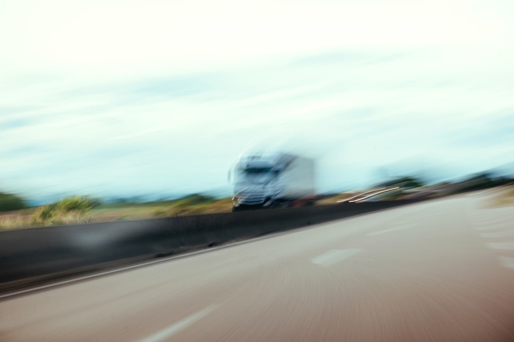 Conceptual silhouette of a defocused truck in motion on highway - pov of driver under alcohol or narcotic substance