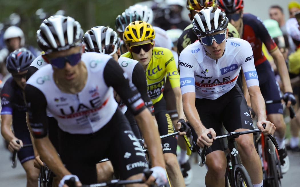 UAE Team Emirates' Slovenian rider Tadej Pogacar wearing the best young rider's white jersey (R) cycles ahead of Jumbo-Visma's Danish rider Jonas Vingegaard wearing the overall leader's yellow jersey (C) in the final ascent of Col du Grand Combier in the final kilometeres of the 13th stage of the 110th edition of the Tour de France cycling race, 138 km between Chatillon-sur-Chalaronne in central-eastern France and Grand Colombier, in the Jura mountains in Eastern France, on July 14, 2023. (Photo by Thomas SAMSON / AFP)