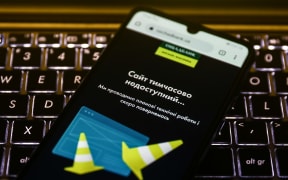 An alert on Oschadbank website is displayed on a mobile phone on February 15, 2022 as the Ukrainian government accused Russia of being behind a cyberattack on dozens of official websites.
