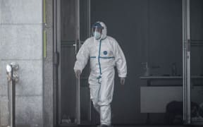 A medical staff member walks outside the Jinyintan hospital, where patients infected by a mysterious SARS-like virus are being treated (January 18, 2020).