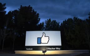 A lit sign is seen at the entrance to Facebook's corporate headquarters