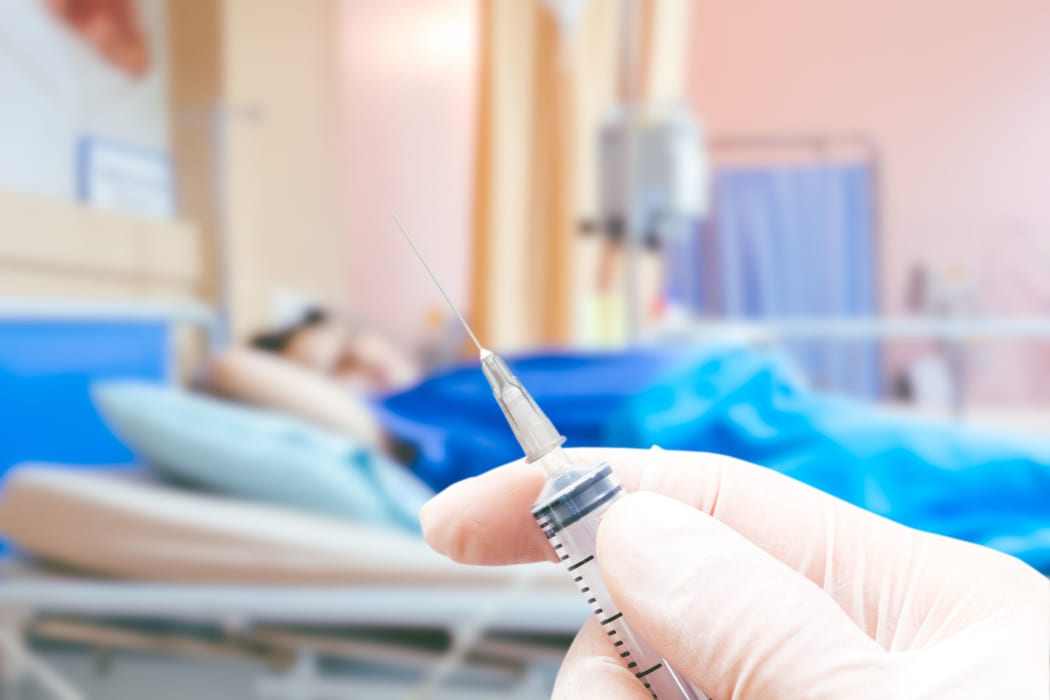 Medical syringe in the doctor's hands on the patient's in room hospital blur background