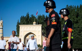 Police patrolling as Muslims leave the Id Kah Mosque after the morning prayer on Eid al-Fitr in the old town of Kashgar in China's Xinjiang Uighur Autonomous Region, on June 26, 2017.