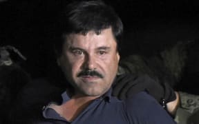 Drug kingpin Joaquin "El Chapo" Guzman is escorted into a helicopter at Mexico City's airport.