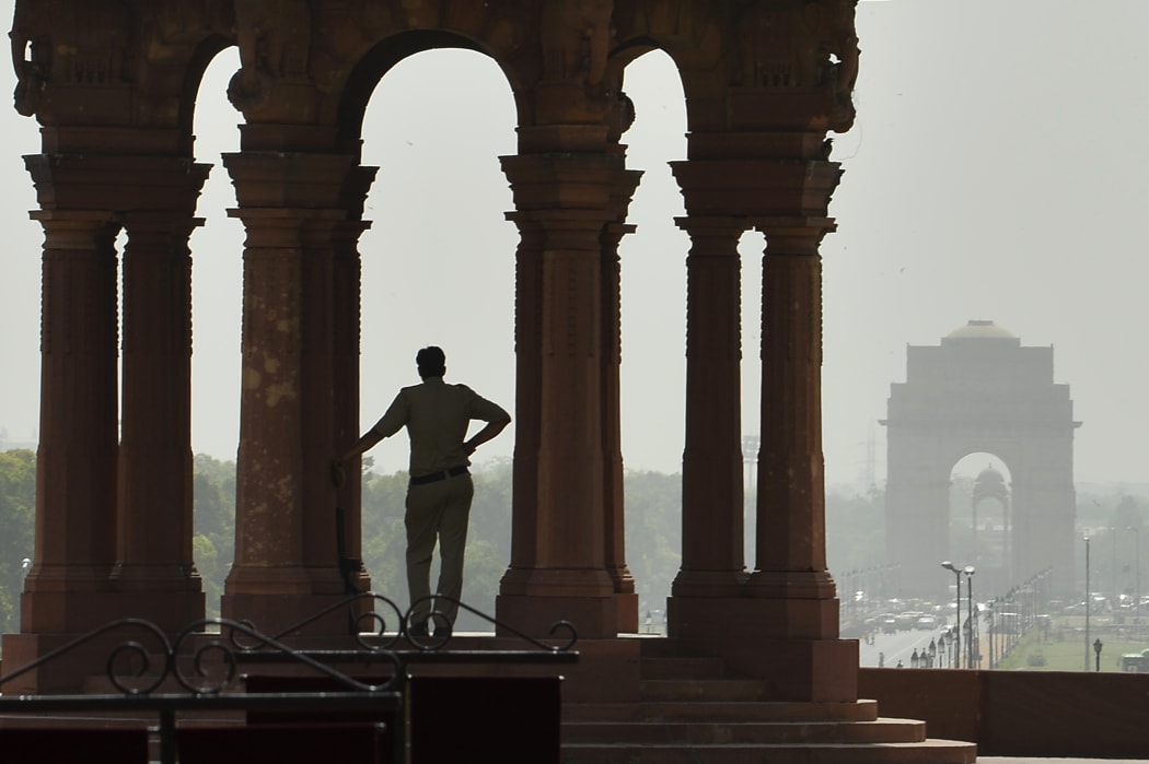 A policeman stands in the shade at the Indian Defence Ministry in New Delhi.