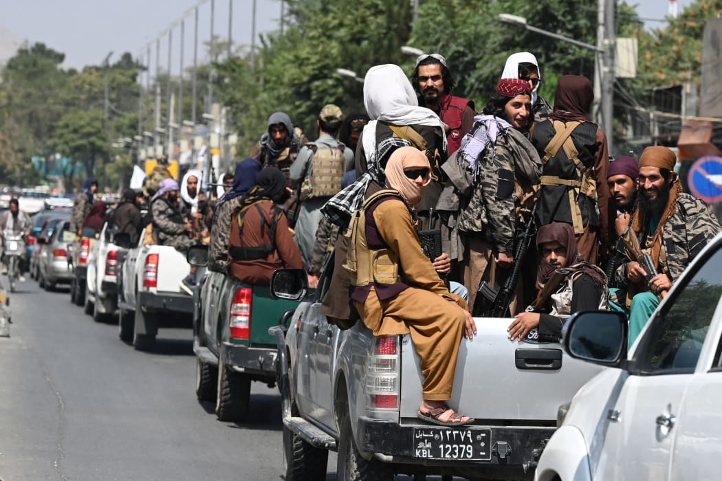 A convoy of Taliban fighters patrol along a street in Kabul