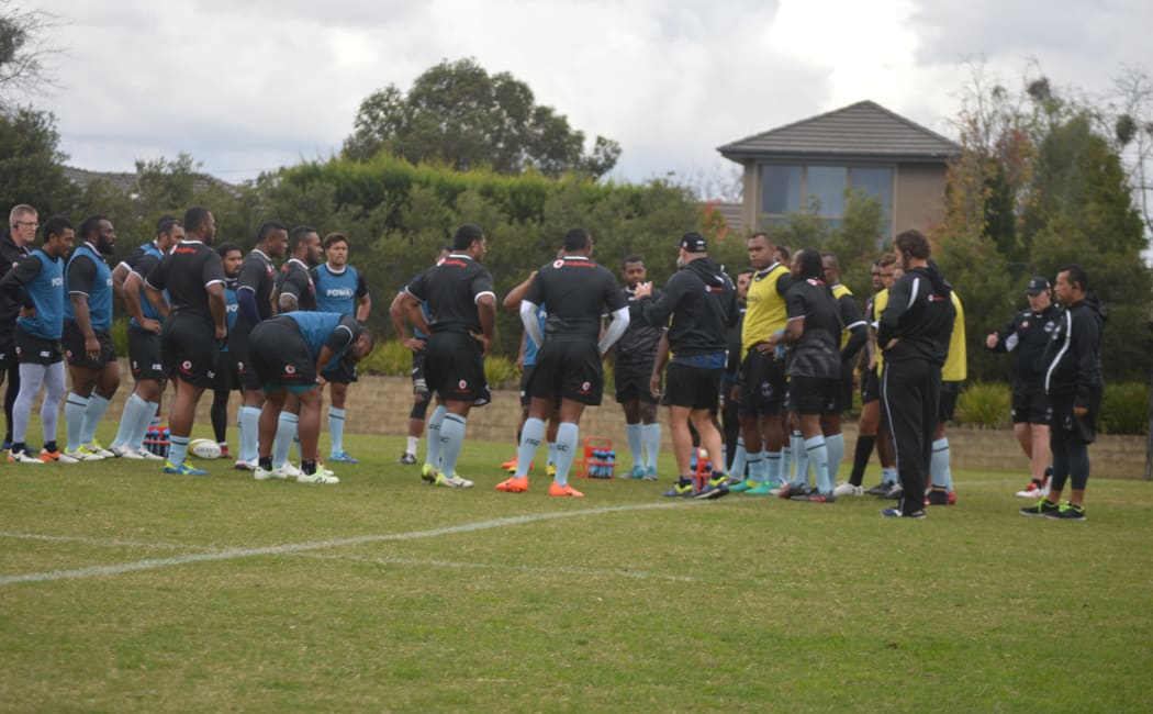 Head coach John McKee (far left) looks on as the Fiji squad huddle up during training.