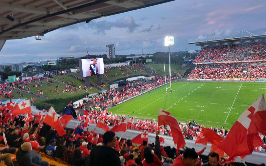 Fans wave the Tonga flag.