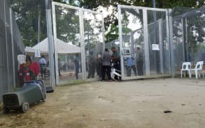 A dispute between refugees and guards at the gate to Oscar compound.